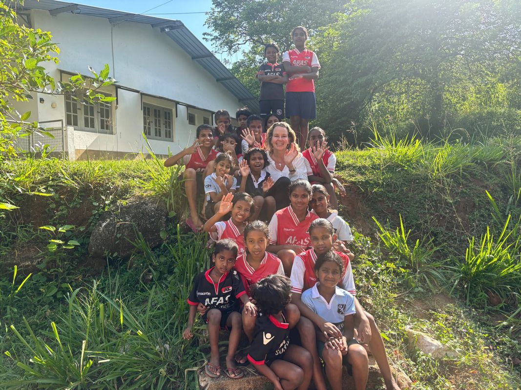 Groep kinderen van Home of Hope op de helling bij een huis