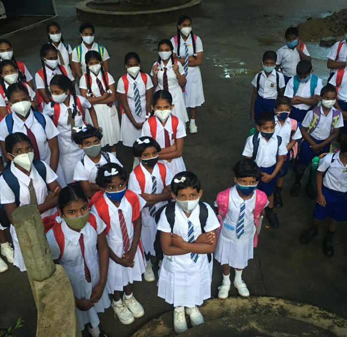 Kinderen van Home of Hope in schooluniform en mondkapjes, klaar om weer naar school te gaan