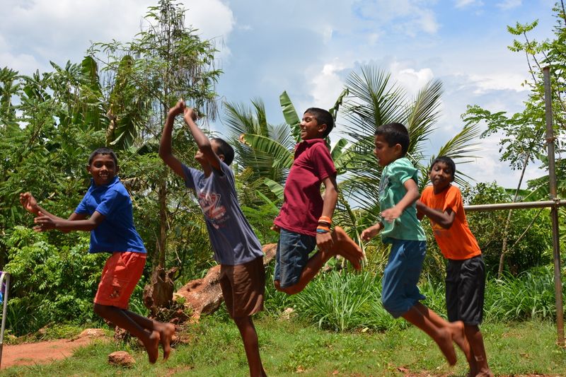 Jongens van Home of Hope springen en spelen buiten